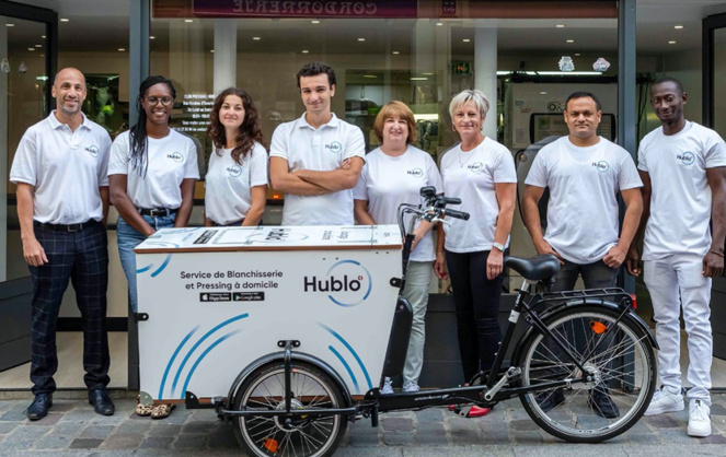 L'équipe d'Hublo posant l'un des triporteurs électriques qui permet de collecter le linge (photo Hublo)