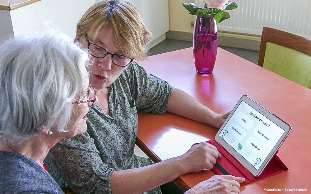 Une personne atteinte de troubles cognitifs s'entrainant sur une tablette numérique