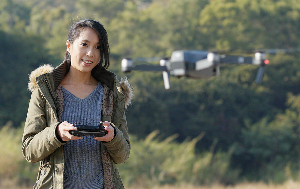 Une télépilote de loisirs contrôlant un drone grand public (photo Adobe Stock)