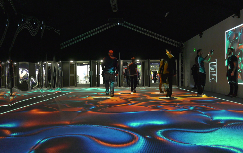 « Augmenta Expérience » :  un espace immersif et interactif utilisant la technologie de suivi Augmenta et le système de particules KAPPS, dans lequel les visiteurs passaient pour aller d’une partie à l’autre du salon. Les murs et le sol étaient interactifs. Designed by Théoriz « Augmenta Expérience » :  un espace immersif et interactif utilisant la technologie de suivi Augmenta et le système de particules KAPPS, dans lequel les visiteurs passaient pour aller d’une partie à l’autre du salon. Les murs et le sol étaient interactifs. Designed by Théoriz