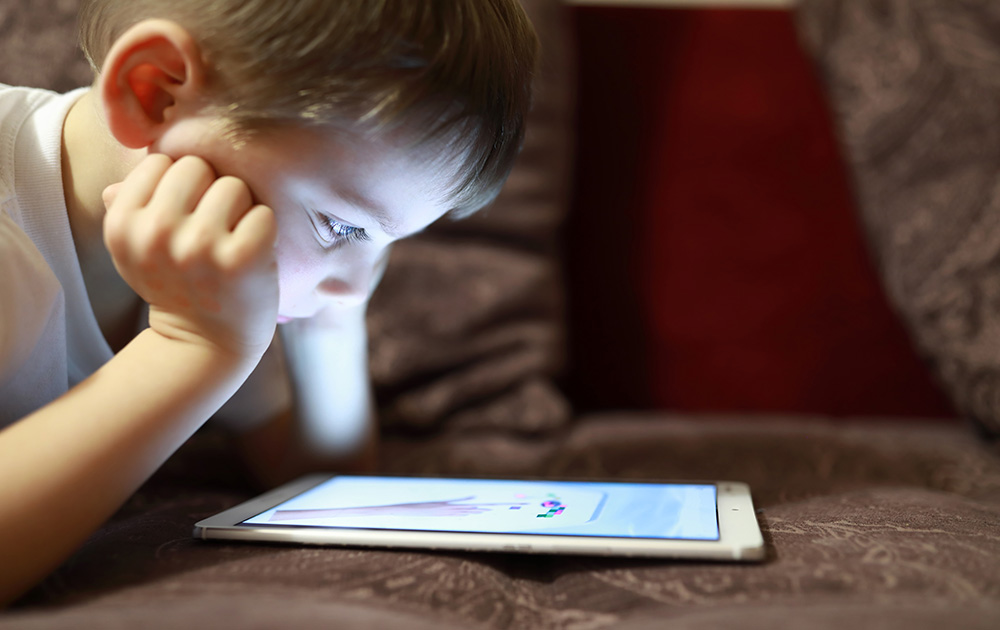 La tablette digitale exerce un pouvoir d'attraction dont les enfants ne peuvent pas se détacher (photo Adobe Stock)